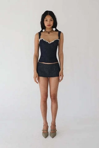 Détail d'un haut corset bleu foncé avec bordure en dentelle blanche et mini-jupe assortie