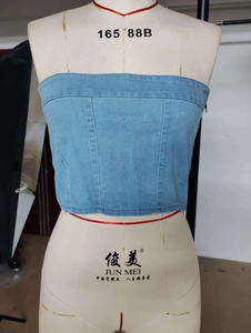 Detail of washed blue denim tube top showing vertical stitching and side metal zipper