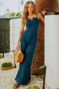 Detail of dark blue denim jumpsuit with spaghetti straps and white contrast stitching