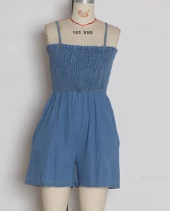 Detailed view of blue smocked denim romper with thin straps on a dress form
