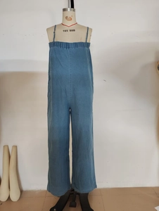 Detail of blue denim jumpsuit with spaghetti straps and elasticated pleated neckline