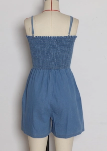Detail view of denim romper showing back smocking and adjustable thin straps