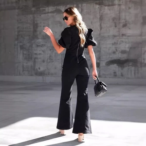 Chic black jumpsuit with puff sleeves and flare wide leg silhouette in urban setting