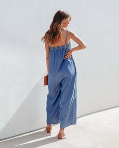 Detail of summer high-waisted denim jumpsuit showing elastic back and ruffled edge