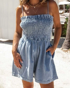 Close-up of the smocked elastic bodice and ruffle neckline on a blue denim romper