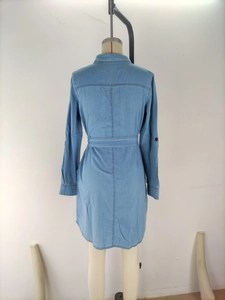 Back view of light blue denim shirt dress on a mannequin with waist belt and collar