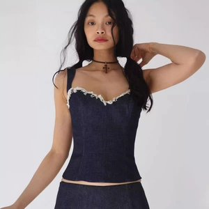 Haut corset en jean ajusté avec décolleté en cœur et détails de bords effilochés