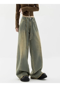 Detail of high-waist wide-leg jeans with vintage wash and matching denim belt accessory