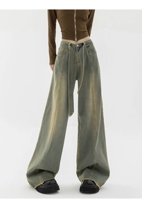 Detail of vintage washed wide leg jeans with high waist belted design and frayed hems