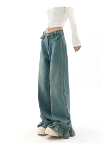 Détail du jean large bleu rétro à taille haute avec bords à volants à la taille et en bas