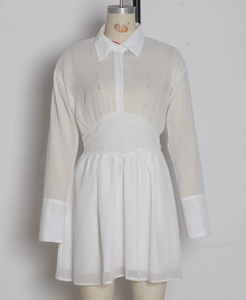 Détail d'une robe chemise blanche à manches longues avec tissu transparent et plissé