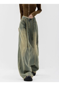 Detail of high-waist dirty wash wide-leg jeans with longitudinal seams and matching belt