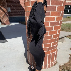 Side view of a black frayed denim jacket paired with a sleek midi dress and furry slides