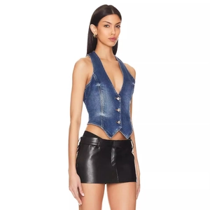 Women's V-neck denim vest in washed blue paired with a sleek black leather mini skirt