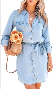 Detail of the waist belt and button closure on this light blue denim mini shirt dress