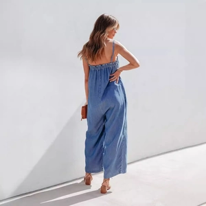 Light blue denim wide-leg jumpsuit with spaghetti straps and stretchy smocked back detail