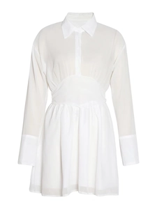 Détail de la robe chemise blanche à manches longues avec taille cintrée et jupe plissée