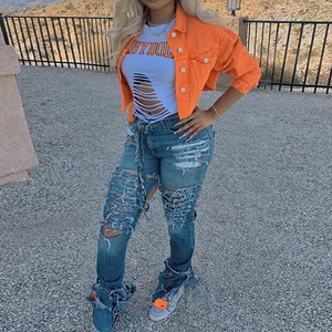 Street style outfit with orange denim jacket, distressed white tee and ripped blue jeans