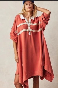 Detail of oversized polo dress in vintage salmon pink with raw edge and contrast white collar