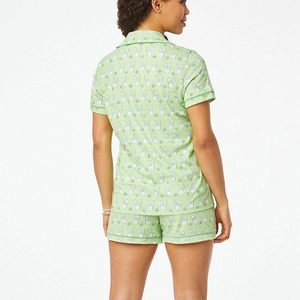 Rear side view of light green women's pajama set featuring white rabbit and clover print