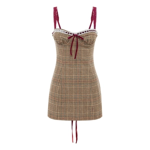 Detailed close-up of brown plaid dress with red lace straps and velvet bow detail