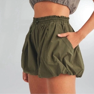 Dettaglio degli shorts a palloncino verde militare con coulisse elastica e tasche laterali