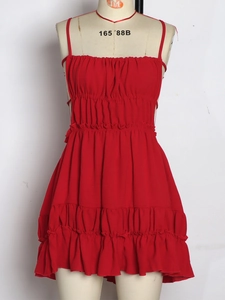 Detail of red backless sundress featuring tiered ruffle hem and pleated bodice details