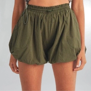 Dettaglio degli shorts a lanterna verde militare con vita elastica a coulisse e tasche
