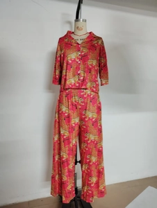 Detail of pink two-piece pajama set with tiger print on short-sleeved top and wide pants