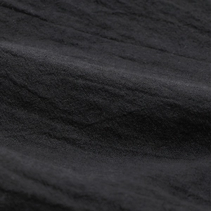 Close-up of black elastic waist cropped trousers in breathable textured fabric
