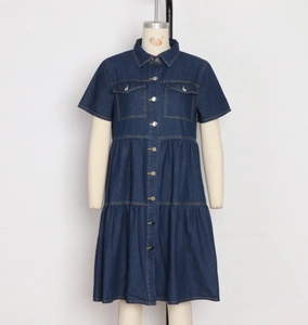 Detailed view of dark blue denim dress featuring silver buttons and tiered ruffle skirt