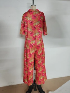 Close-up of leopard and gold scroll print on fuchsia two-piece loungewear set