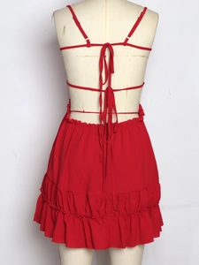 Detail of red backless halter dress showing delicate tie-up straps and ruffled hemline