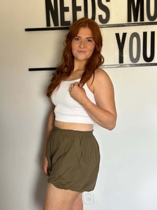Dettaglio del crop top bianco a coste e pantaloncini casual verde oliva con coulisse