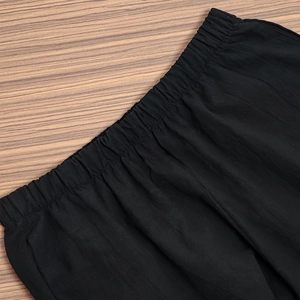 Detailed close-up of elastic waistband with reinforced stitching on black casual pants