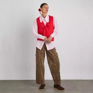 Detail of red quilted vest with bow ties paired with a striped shirt and leopard pants