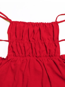 Close-up of red bodycon dress featuring smocked fabric detail and thin shoulder straps