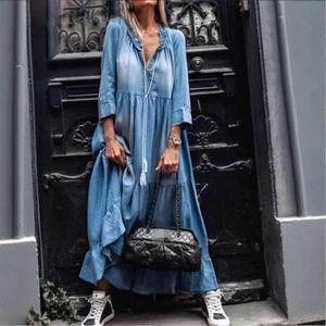 Dettaglio dell'abito in denim azzurro con scollo a V a balze e gonna a balze