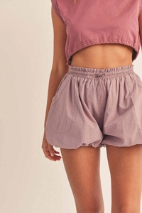 Dettaglio di pantaloncini a vita alta rosa polvere con coulisse elastica e grandi tasche