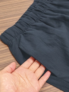 Detail view of elastic waistband and side pocket on navy casual cropped pants