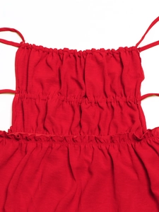 Detail of red ruched dress with smocked elastic fabric and delicate spaghetti straps