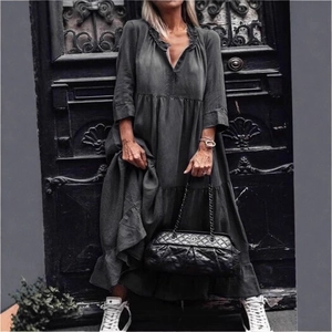 Dettaglio dell'abito lungo in denim grigio scuro con gonna a balze e scollo a V pieghettato