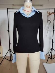 Detail of V-neck knit sweater with light blue striped shirt collar and cuffs faux two-piece
