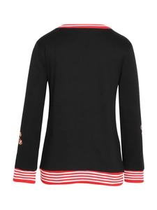 Detail of gingerbread man embroidery and red-white striped cuffs on black Christmas top