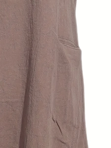Détail d'une robe marron avec une poche latérale et une texture de tissu froissée