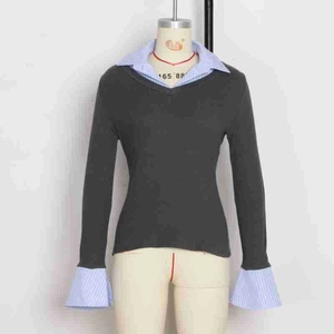 Detail of V-neck knitted top with striped shirt patchwork and flared cuffs on mannequin