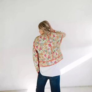 Back view of a quilted floral jacket for women with vivid orange piping and cotton padding