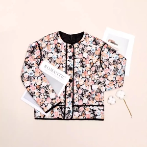 Detail of floral quilted jacket with round neck, black trim and romantic floral patterns