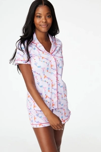 Detail of short sleeve pajama set featuring cute cartoon prints and pink piping edges