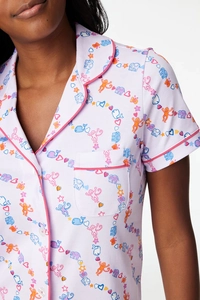Detail of short sleeve pajama top featuring notch collar and colorful animal prints